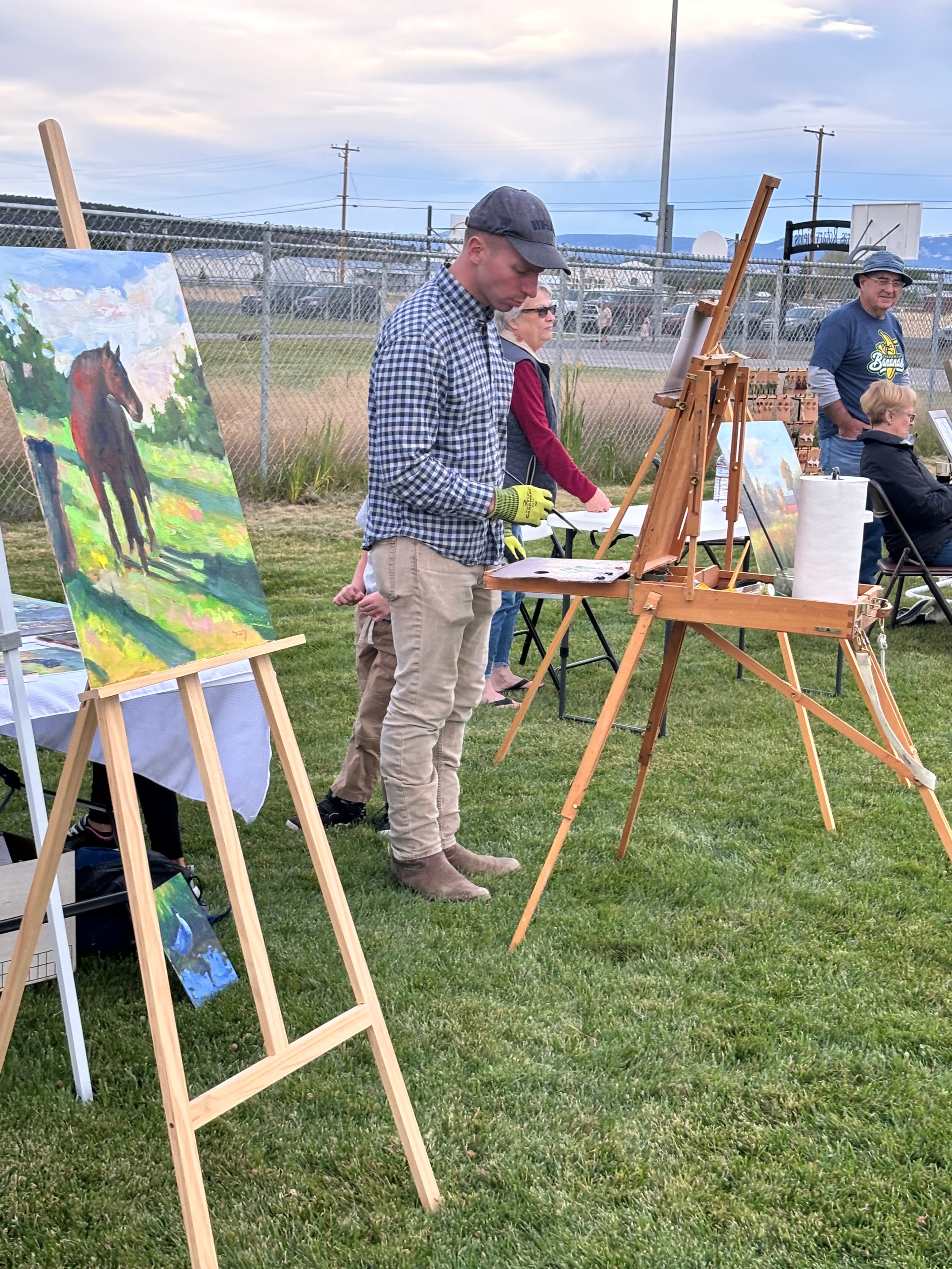 Artists painting on easels outdoors at Art in the Park community event